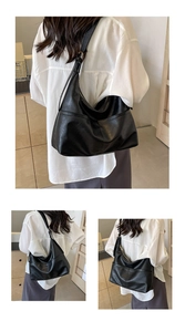 Detail of minimalist black hobo tote showing large capacity and textured glossy finish