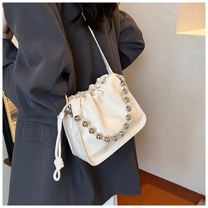 Close-up of creamy white drawstring bucket bag with shiny PU leather and silver bead chain