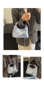 Detailed view of quilted denim hobo bag with pearl drawstrings and chain strap