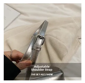 Gros plan sur la bandoulière réglable en cuir argenté avec boucle métallique