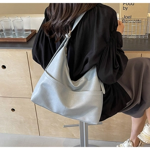 Detail of light blue crescent tote bag showing the adjustable strap and faux leather texture