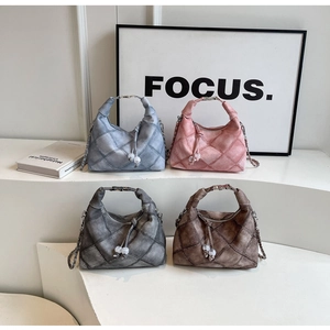 Details von vier gesteppten Handtaschen mit Perlenquasten auf weißen Stufen