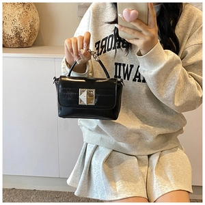 Vue détaillée du sac en cuir verni noir avec une boucle carrée argentée audacieuse
