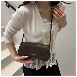 Close-up of deep brown embossed snakeskin texture on a luxury crossbody bag
