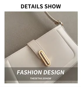 Détail d'un sac à bandoulière crème avec boucle dorée ovale et coutures précises