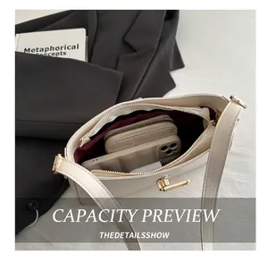Vue de dessus du sac crème montrant sa grande capacité avec téléphone et portefeuille