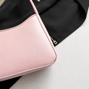 Detail view of pink leather handbag showing fine stitching and premium smooth texture