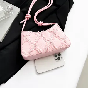 Detailed macro view of pink quilted tote bag with brushed texture and slim leather strap
