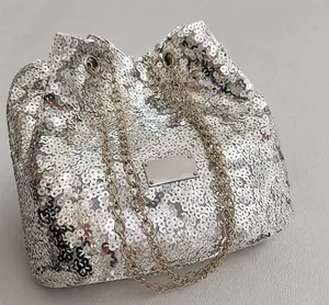 Detailed close-up of shiny silver sequin bucket bag with premium metal chain and plate