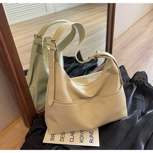 Detail of off-white textured PU leather tote bag with adjustable shoulder strap and pocket
