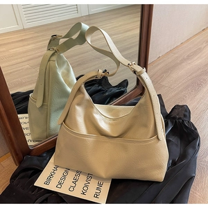 Detail of beige hobo bag showing pleated faux leather texture and adjustable shoulder strap