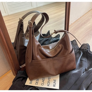 Detail of brown faux leather tote with lychee texture and adjustable shoulder strap