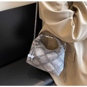 Detail der Vintage-Tasche mit Denim-Textur, Metallkette und Marmorperlen-Akzenten