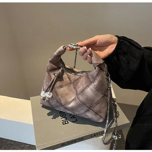 Detailansicht der braunen Stepptasche mit Silberkette und Kordelzug aus weißen Perlen