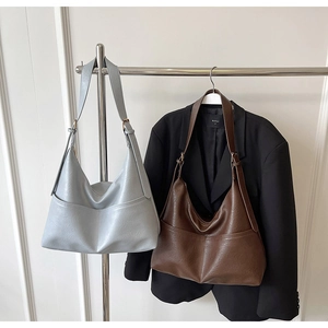 Detail of hobo shoulder bags in light blue and dark brown with wide strap and side pocket