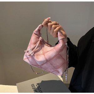 Detail der rosa Denim-Tasche mit Steppmuster, Knotengriff und silberner Kette