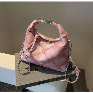 Detail der rosa Jeans-Umhängetasche mit Silberschnalle und Steppmuster auf Buch