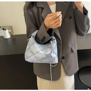 Detail der hellblauen Denim-Tasche mit Steppmuster und Kettenriemen-Design