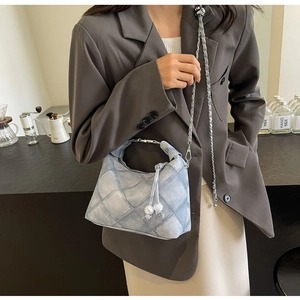 Detail der hellblauen Denim-Tasche mit Steppmuster und Perlen-Kettenschultergurt