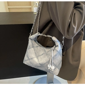 Detail der hellblauen Denim-Tasche mit Silberkette und gesteppten Mustern