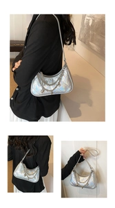 Detail view of silver holographic quilted bag with metal chain and heart pendant