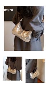 Detail of silver metallic quilted half-moon bag with multi-layer chain strap details