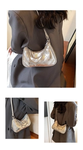 Detail of silver metallic quilted hobo bag with chain strap and leather shoulder handle