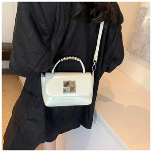 Détail du sac à bandoulière en cuir crème avec poignée perle argent et fermoir diamant