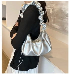Detail of silver metallic scrunchie strap shoulder bag with ruched texture and side drawstring