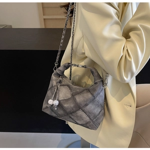 Detailansicht der grauen Stepptasche mit Kettengurt und weißen Perlenanhängern für Damen