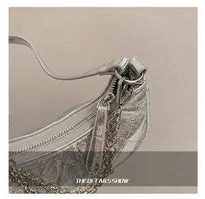 Detailed close-up of silver pleated handbag featuring durable metal chain and quality zipper