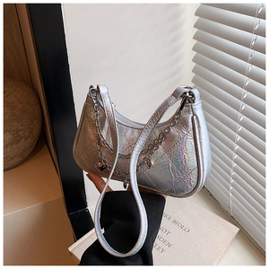 Close-up of holographic silver quilted hobo bag with metal heart chain detail