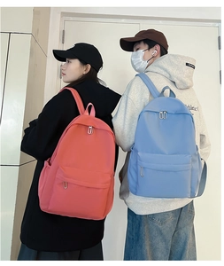 Side view of pink and blue lightweight nylon student backpacks shown on models