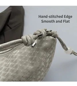 Détail du sac à motif croissant avec bandoulière nouée et perle dépolie décorative