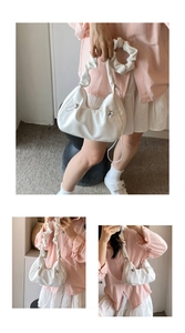 Detail of white scrunchie handle and pleated PU leather texture on a crescent shoulder bag