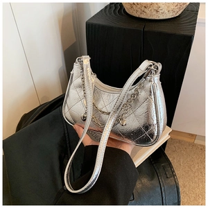 Close-up of silver quilted chain bag with metallic finish and crescent moon shape