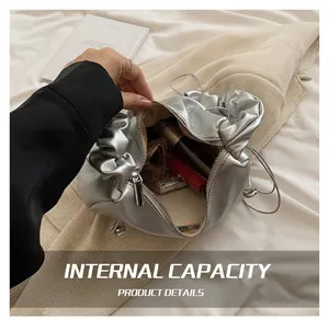Interior capacity detail of silver pleated dumpling bag showing daily essentials