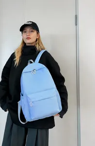 Close-up of lightweight light blue nylon backpack with zipper pockets on female model