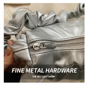 Macro shot of silver pleated cloud bag featuring premium metal zipper hardware detail