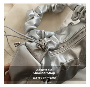 Macro shot of silver ruched bag detail with adjustable strap metal buckle and drawstring