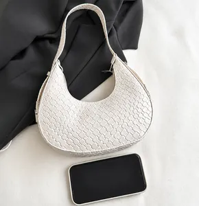 Detail of white moon bag featuring crocodile pattern texture and silver metal hardware