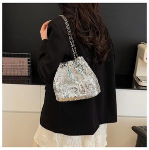 Silver sequin bucket bag with metal chain strap shown in a lifestyle setting