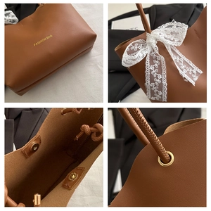 Detail view of brown tote bag with fashion text, white lace bow, and magnetic closure