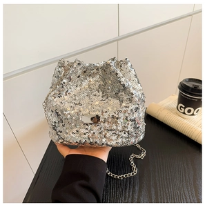 Close-up of sparkling silver sequin bucket bag with metal chain strap and drawstring