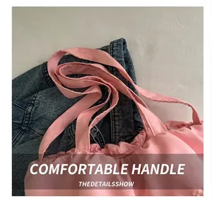 Close-up of pink pleated fabric tote bag showing ruffled edge details on denim background