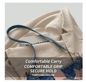 Detail der blauen Denim-Sterntasche mit rosa Lederbesatz und metallischer Kettenverzierung