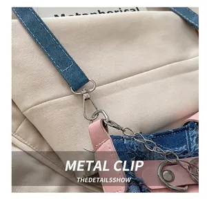 Nahaufnahme von silbernem Metallhaken an einer Denim und pinken Leder-Patchworktasche