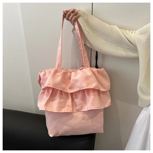 Detailed close-up of pink layered ruffle design on canvas tote bag with shoulder strap