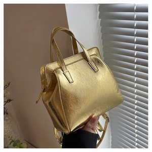 Detail of gold metallic textured tote bag featuring fashion bag embossing and dual handles