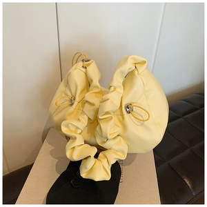 Detail of light yellow ruched cloud bag showing soft pleated handle and drawstring closure